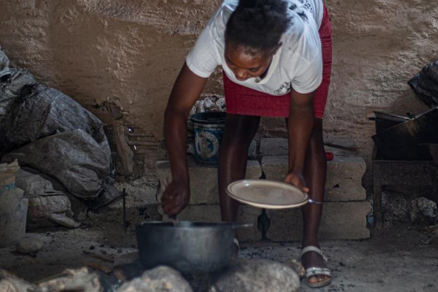 uma mulher prepara uma refeição no haiti