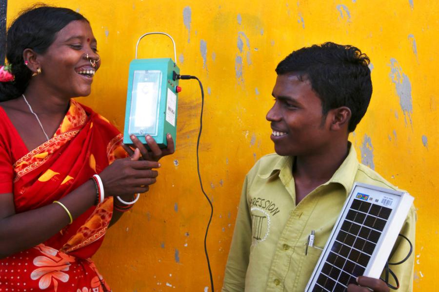 Mulher que foi treinadas em engenharia solar em Tinginaput, na Índia, segura uma lâmpada que iluminará sua casa