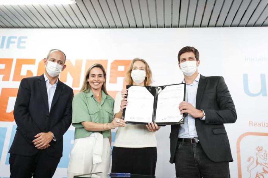 A representante do UNICEF, Florence Bauer, e o prefeito de Recife, João Campos, mostram o acordo de cooperação assinado