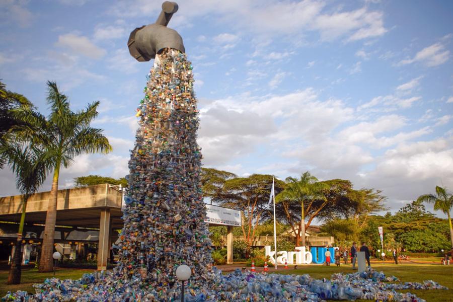 imagem de uma instalação mostrando uma torneira gigante despejando plásticos em vez de água