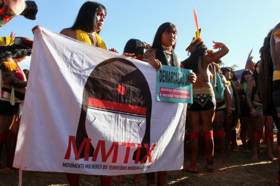 grupo de mulheres indígenas segura uma faixa durante a Marcha das Mulheres Indígenas, Acampamento Terra Livre em 2023